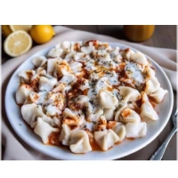 Traditionele Turkse dumplings met yoghurt- en tomatensaus.
